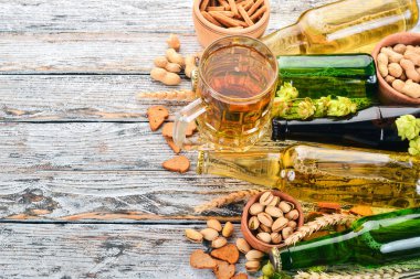 Arka plan bira ve aperatifler. Atlama, bira, cips, Kuruyemiş. Beyaz ahşap zemin üzerinde. Metin için özgür yer. Üstten görünüm.