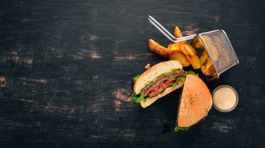 Fırında patates ve et, domates ve soğan ile Burger. Ahşap bir arka plan üzerinde. Metin için özgür yer. Üstten görünüm.