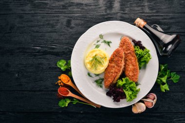 Pirzola et bir tabak patates püresi ile. Eski ahşap arka plan üzerinde. Metin için özgür yer. Üstten görünüm.