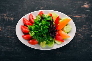 Dilimlenmiş taze sebze bir tabak. Salata. Eski ahşap arka plan üzerinde. Metin için özgür yer. Üstten görünüm.