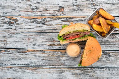 Fırında patates ve et, domates ve soğan ile Burger. Ahşap bir arka plan üzerinde. Metin için özgür yer. Üstten görünüm.