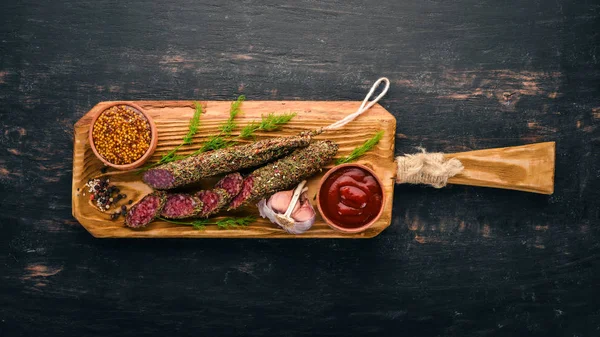 Sosis Fuet. Salam baharatlar ile. Siyah bir arka plan üzerinde. Üstten görünüm. Metniniz için boş alan.