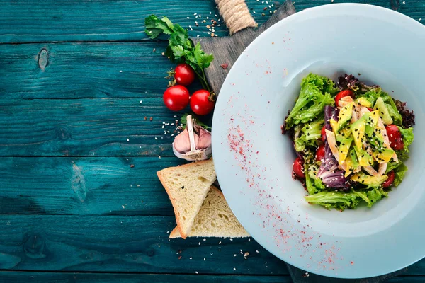 Sebze salatası tavuk fileto ve avokado. Ahşap bir arka plan üzerinde. Metin için özgür yer. Üstten görünüm.