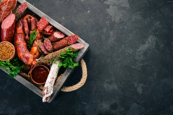 Sosis ve aperatifler mezarda ürün yelpazesine. Sosis Fuet, salam, paperoni. Siyah bir arka plan üzerinde. Üstten görünüm. Metniniz için boş alan.