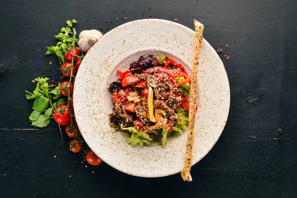 Dana eti, mantar ve susam ile taze sebze salatası. Eski arka plan üzerinde. Ücretsiz kopya alanı. Üstten görünüm.