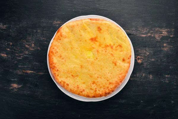 Khachapuri peynir ile. Gürcü mutfağı. Eski ahşap arka plan üzerinde. Metin için özgür yer. Üstten görünüm.