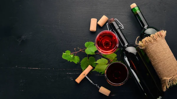 红酒放在瓶子里 里面有玻璃和葡萄 在黑色的木质背景 文本的可用空间 顶部视图 — 图库照片