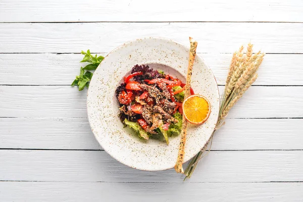 Dana eti, mantar ve susam ile taze sebze salatası. Eski arka plan üzerinde. Ücretsiz kopya alanı. Üstten görünüm.