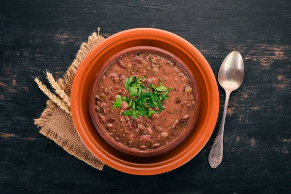 Bean. Haricot Soup. Georgian traditional cuisine. On the old wooden background. Free space for text. Top view. — Stock Image Bean Haricot Soup Georgian Traditional Cuisine Old Wooden Background Free Stock Picture