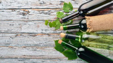 Kırmızı ve beyaz şarap şişeleri ve gözlük kümesi. Üzüm. Beyaz ahşap zemin üzerinde. Metin için özgür yer. Üstten görünüm.