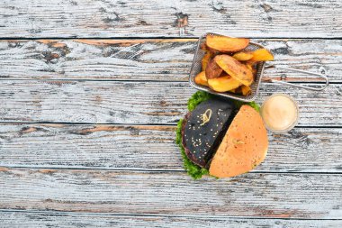 Fırında patates ve et, domates ve soğan ile Burger. Ahşap bir arka plan üzerinde. Metin için özgür yer. Üstten görünüm.