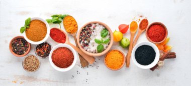 Baharat ve otlar Beyaz ahşap bir masa üzerinde bir dizi. Fesleğen, karabiber, safran, baharatlar. Hint geleneksel mutfak. Üstten görünüm. Ücretsiz kopya alanı.