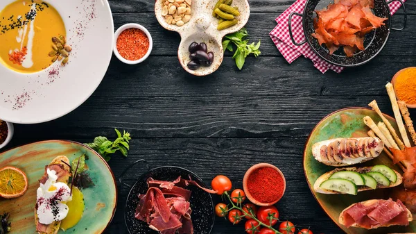 Yemekleri kümesi. Balkabağı çorbası, avokado sandviç, jambon ve mantar. Üstten görünüm. Metniniz için boş alan. Ahşap bir arka plan üzerinde.