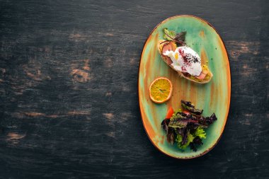 Avokado, pastırma ve haşlanmış yumurta ile sandviç. Üstten görünüm. Metniniz için boş alan. Ahşap bir arka plan üzerinde.