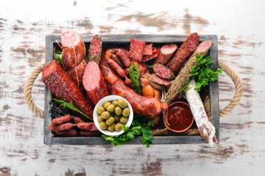 Sosis ve aperatifler mezarda ürün yelpazesine. Sosis Fuet, salam, paperoni. Beyaz ahşap zemin üzerinde. Üstten görünüm. Metniniz için boş alan.