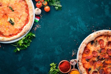 Pizza kümesi. İtalyan mutfağı. Siyah taş arka plan üzerinde. Ücretsiz kopya alanı. Üstten görünüm.