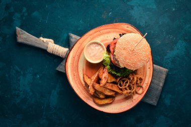 Hamburger eti, soğan, domates ve fırında patates ile. Eski arka plan üzerinde. Ücretsiz kopya alanı. Üstten görünüm.