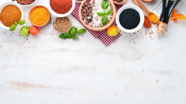 Baharat ve otlar Beyaz ahşap bir masa üzerinde bir dizi. Fesleğen, karabiber, safran, baharatlar. Hint geleneksel mutfak. Üstten görünüm. Ücretsiz kopya alanı.