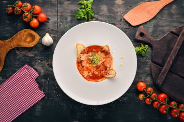 Parmesan peyniri ve kruton ekmek ile domates çorbası. Üstten görünüm. Metniniz için boş alan. Ahşap bir arka plan üzerinde.