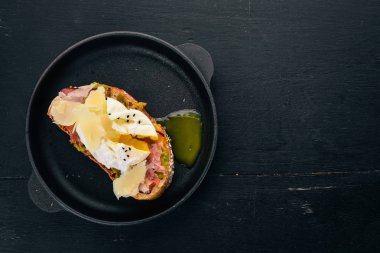 Haşlanmış yumurta, avokado ve parmesan peynirli sandviç. Ahşap bir arka plan üzerinde. Metin için özgür yer. Üstten görünüm.