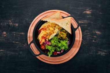 Sebze ve mantar bir tavada omlet. Ahşap bir arka plan üzerinde. Metin için özgür yer. Üstten görünüm.