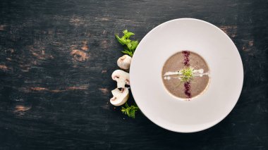 Kremalı mantar çorbası püresi. Üstten görünüm. Metniniz için boş alan. Ahşap bir arka plan üzerinde.