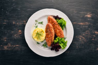 Pirzola et bir tabak patates püresi ile. Eski ahşap arka plan üzerinde. Metin için özgür yer. Üstten görünüm.