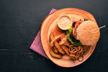 Hamburger eti, soğan, domates ve fırında patates ile. Eski arka plan üzerinde. Ücretsiz kopya alanı. Üstten görünüm.