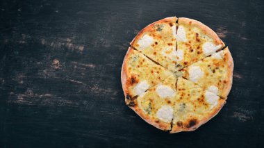 Pizza Quattro Formaggi. İtalyan mutfağı. Ahşap bir arka plan üzerinde. Metin için özgür yer. Üstten görünüm.