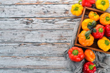 Renkli biber mezarda. Üstten görünüm. Beyaz ahşap zemin üzerinde. Metin için boş alan.