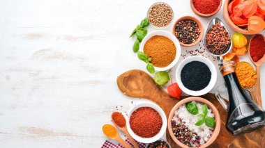 Baharat ve otlar Beyaz ahşap bir masa üzerinde bir dizi. Fesleğen, karabiber, safran, baharatlar. Hint geleneksel mutfak. Üstten görünüm. Ücretsiz kopya alanı.