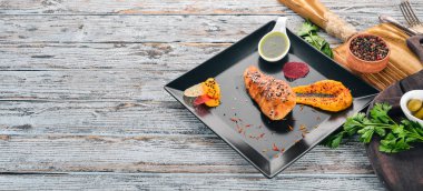 Siyah bir plaka üzerinde soslu Fırında tavuk fileto. Ahşap bir arka plan üzerinde. Metin için özgür yer. Üstten görünüm.