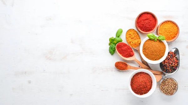 Baharat ve otlar Beyaz ahşap bir masa üzerinde bir dizi. Fesleğen, karabiber, safran, baharatlar. Hint geleneksel mutfak. Üstten görünüm. Ücretsiz kopya alanı.