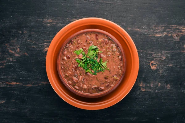 Bean. Haricot Soup. Georgian traditional cuisine. On the old wooden background. Free space for text. Top view. — Stock Image Bean Haricot Soup Georgian Traditional Cuisine Old Wooden Background Free Stock Image