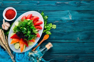 Dilimlenmiş taze sebze bir tabak. Salata. Eski ahşap arka plan üzerinde. Metin için özgür yer. Üstten görünüm.