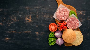 Ham burger yemek bir hamburger etli. Siyah ahşap arka plan üzerinde. Üstten görünüm. Ücretsiz kopya alanı.