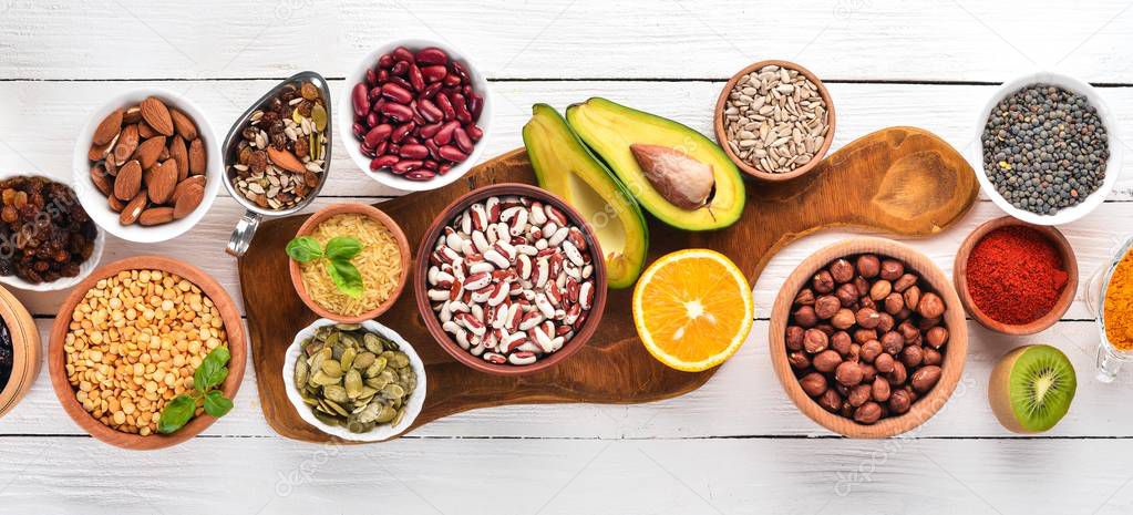 Superfoods Healthy food. Nuts, berries, fruits, and legumes. On a white wooden background. Top view. Free copy space.