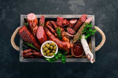 Sosis ve aperatifler mezarda ürün yelpazesine. Sosis Fuet, salam, paperoni. Siyah bir arka plan üzerinde. Üstten görünüm. Metniniz için boş alan.