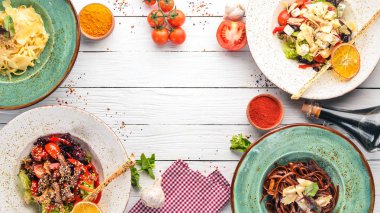 Yemekleri kümesi. Parmesan peyniri ve sebze salatası ve mavi peynirli makarna. Üstten görünüm. Metniniz için boş alan. Ahşap bir arka plan üzerinde.