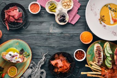 Yemekleri kümesi. Balkabağı çorbası, avokado sandviç, jambon ve mantar. Üstten görünüm. Metniniz için boş alan. Ahşap bir arka plan üzerinde.