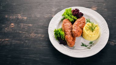 Pirzola et bir tabak patates püresi ile. Eski ahşap arka plan üzerinde. Metin için özgür yer. Üstten görünüm.