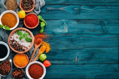 Baharat ve otlar üzerinde mavi ahşap bir masa. Fesleğen, karabiber, safran, baharatlar. Hint geleneksel mutfak. Üstten görünüm. Ücretsiz kopya alanı.