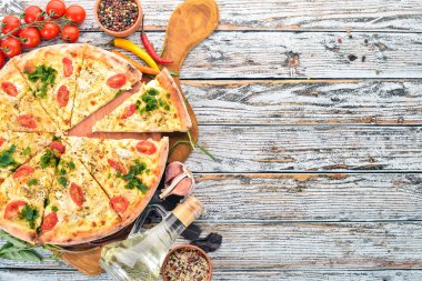 Pizza domates, suluguni peynir ve fesleğen. İtalyan mutfağı. Ahşap bir arka plan üzerinde. Metin için özgür yer. Üstten görünüm.
