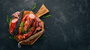 Sosis Fuet, salam, karton mutfak gemide. Siyah bir arka plan üzerinde. Üstten görünüm. Metniniz için boş alan.