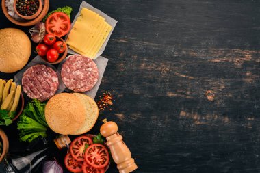 Ham burger yemek bir hamburger etli. Siyah ahşap arka plan üzerinde. Üstten görünüm. Ücretsiz kopya alanı.