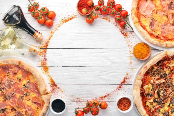 A set of Italian pizza. Italian cuisine. On a white wooden background. Free copy space. Top view.