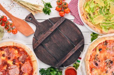 İtalyan pizza kümesi. İtalyan mutfağı. Beyaz ahşap zemin üzerinde. Ücretsiz kopya alanı. Üstten görünüm.