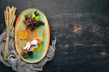 Avokado, pastırma ve haşlanmış yumurta ile sandviç. Üstten görünüm. Metniniz için boş alan. Ahşap bir arka plan üzerinde.