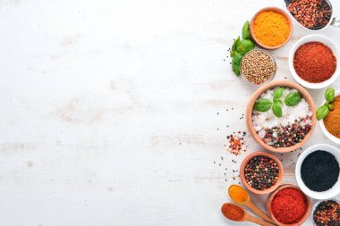 Baharat ve otlar Beyaz ahşap bir masa üzerinde bir dizi. Fesleğen, karabiber, safran, baharatlar. Hint geleneksel mutfak. Üstten görünüm. Ücretsiz kopya alanı.