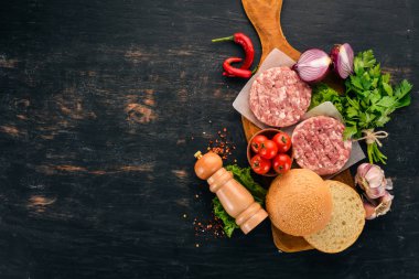 Ham burger yemek bir hamburger etli. Siyah ahşap arka plan üzerinde. Üstten görünüm. Ücretsiz kopya alanı.